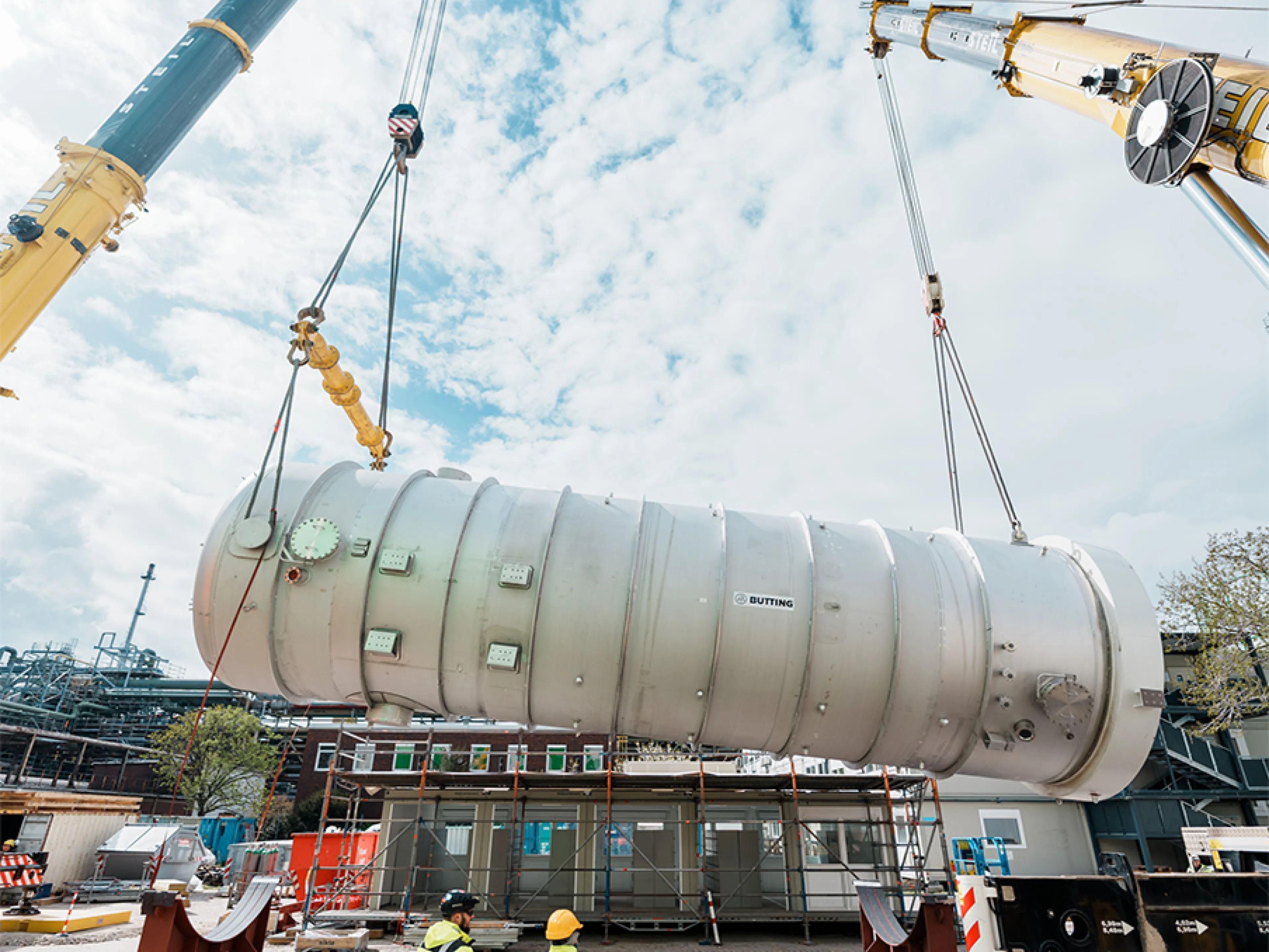 Nachhaltige Energieerzeugung bei BASF: Ein Schwergewicht: Zwei Kräne heben den fast 100 Tonnen wiegenden Fallfilmverdampfer in die Luft