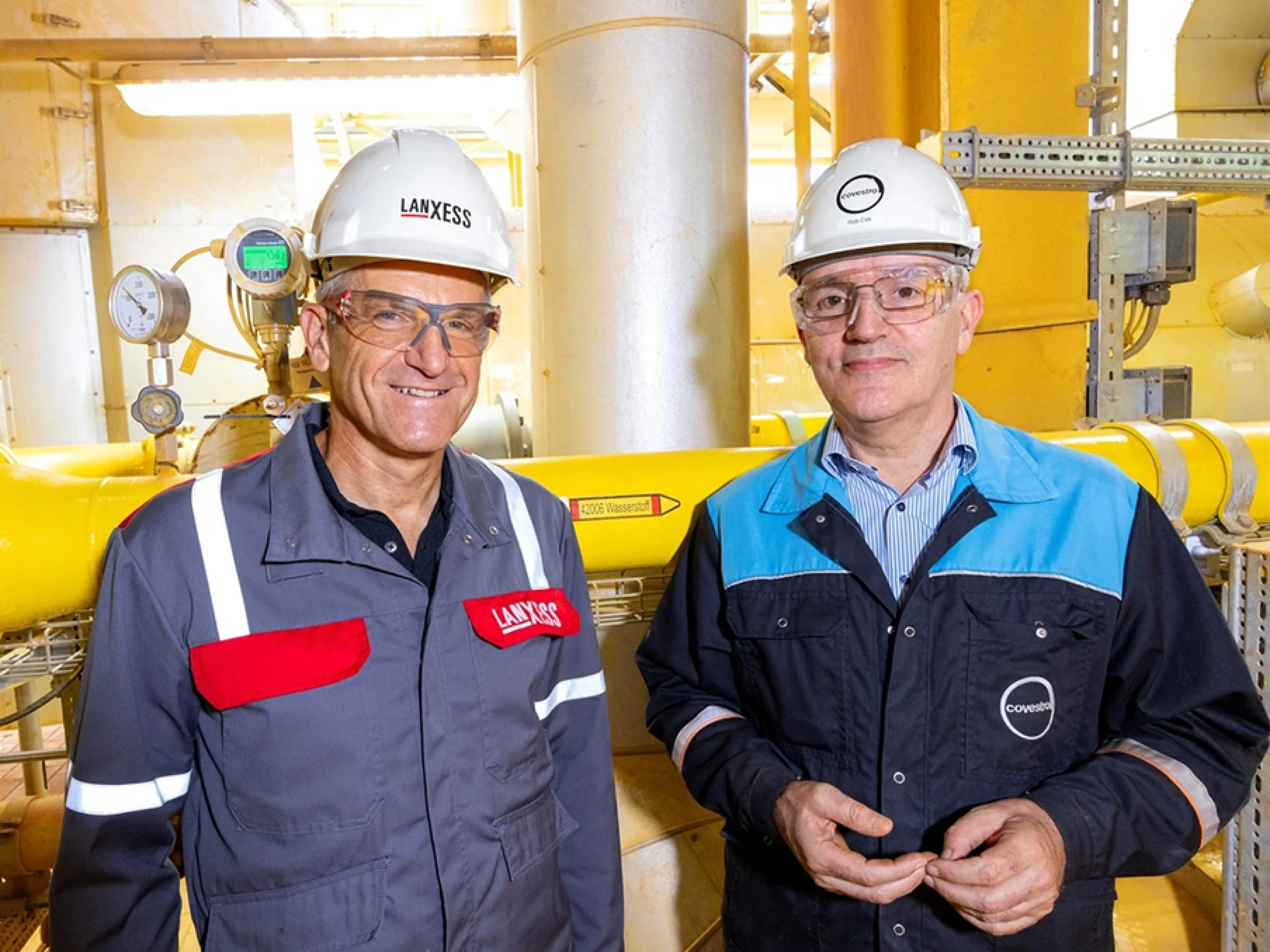 Micheal Ertl, Leiter Geschäftsbereich Inorganic Pigments, und Rob Eek, Produktionsleiter bei Covestro in Krefeld-Uerdingen, vor der neuen Wasserstoff-Leitung, die die Anlage für Eisenoxide von Lanxess versorgt, Bild: Lanxess