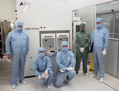 Die Kooperationspartner des BASF und Fraunhofer IPMS vor der Prozessanlage „LAM Sabre Extreme“, Bild: Fraunhofer IPMS Die Kooperationspartner des BASF und Fraunhofer IPMS vor der Prozessanlage „LAM Sabre Extreme“