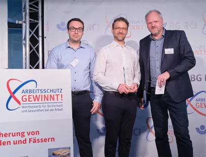 Gewinner des Arbeitsschutz-Wettbewerbs: Jonas Binninger und Andreas Unterhuber von Wacker Chemie mit Thomas Leitmann, Vorsitzender des Präventionsausschusses der Vertreterversammlung der BG RCI