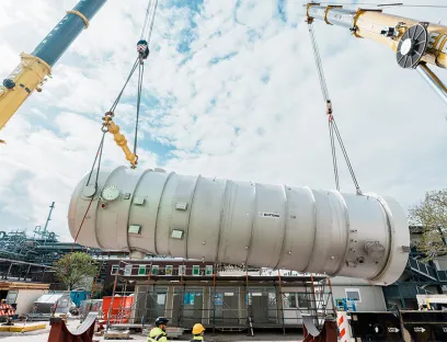 Nachhaltige Energieerzeugung bei BASF: Ein Schwergewicht: Zwei Kräne heben den fast 100 Tonnen wiegenden Fallfilmverdampfer in die Luft