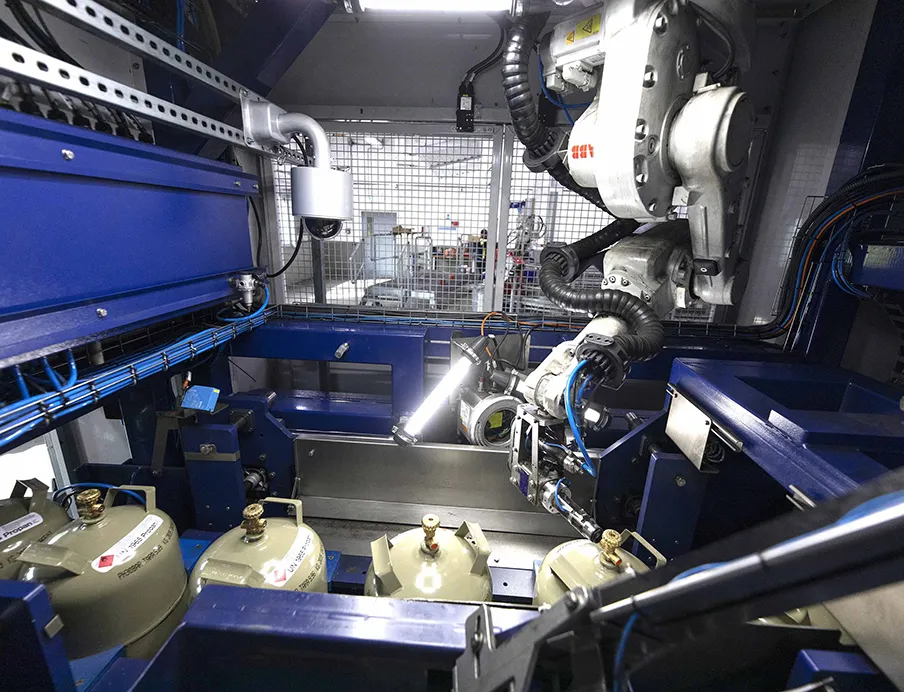 Nachdem die Ventilschutzkappen entfernt wurden, schraubt ein „IRB 1600“-Roboter von ABB Robotics die Ventilverschlussmuttern von den Gasflaschen