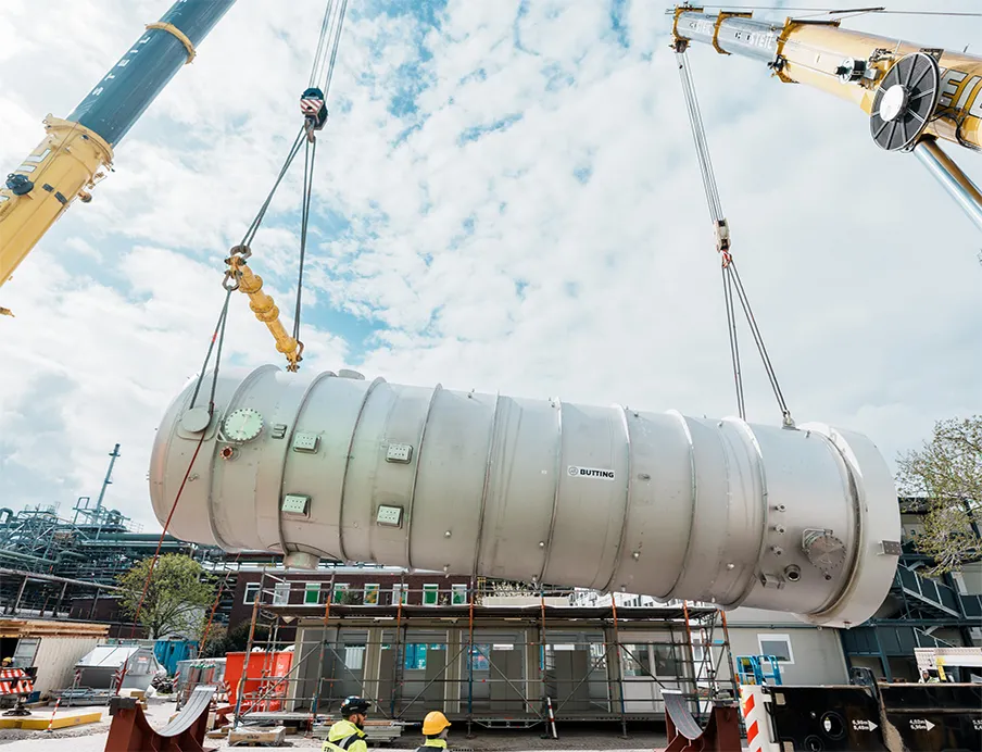 Nachhaltige Energieerzeugung bei BASF: Ein Schwergewicht: Zwei Kräne heben den fast 100 Tonnen wiegenden Fallfilmverdampfer in die Luft